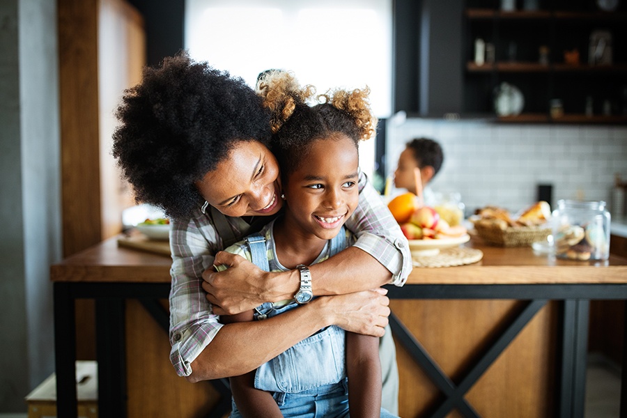 Personal Insurance - Happy Mother Embracing Her Child in the Kitchen